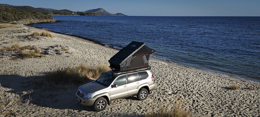Cort de plafon Overlander deschis pe mașină, pe plajă, la mare